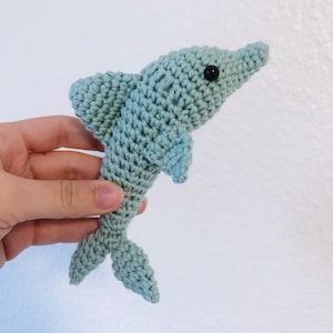 May include: A crocheted light blue dolphin toy with black eyes.