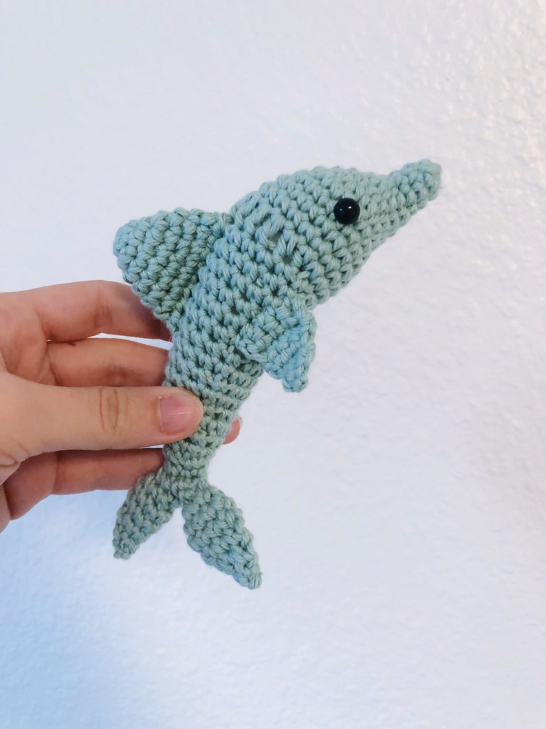May include: A crocheted light blue dolphin toy with black eyes.