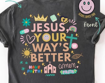 May include: Dark gray t-shirt with colorful text and graphics. The back of the shirt says "JESUS, YOUR WAY'S BETTER" with religious symbols. The front has a smiley face and the text "JESUS LOVES YOU".