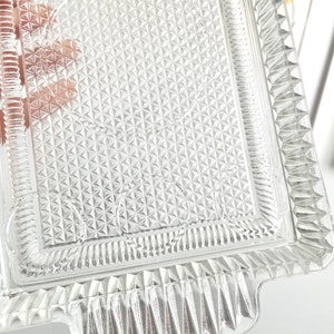 Puede incluir: Bandeja rectangular de vidrio transparente con un patr&oacute;n de diamantes texturizado y bordes decorativos. La bandeja tiene asas en cada extremo, ideal para servir aperitivos o postres.