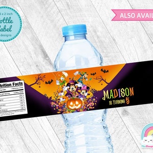 May include: Halloween-themed water bottle label featuring Mickey Mouse and friends. The label is orange, purple, and black with a nutrition facts label on the left side. The text on the label reads "MADISON IS TURNING 5".