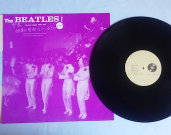 May include: A vinyl record album by The Beatles. The album cover is purple with the band's name and Japanese text. The record itself is black with a white label. The album is in its original sleeve.