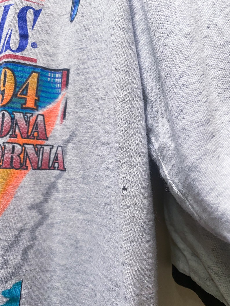 May include: Gray t-shirt with a colorful graphic print featuring the text "94" and "California".