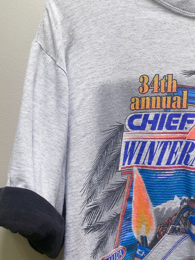 May include: Gray t-shirt with a graphic print of a boat racing on water with flames and the text "34th annual Chief Winter Nationals".