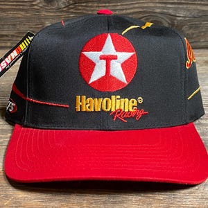 Könnte beinhalten: Schwarze und rote Baseballkappe mit dem Havoline Racing Logo. Die Kappe hat einen roten Schirm und eine schwarze Krone mit dem Texaco Sternlogo. Ein NASCAR-Etikett ist angebracht.