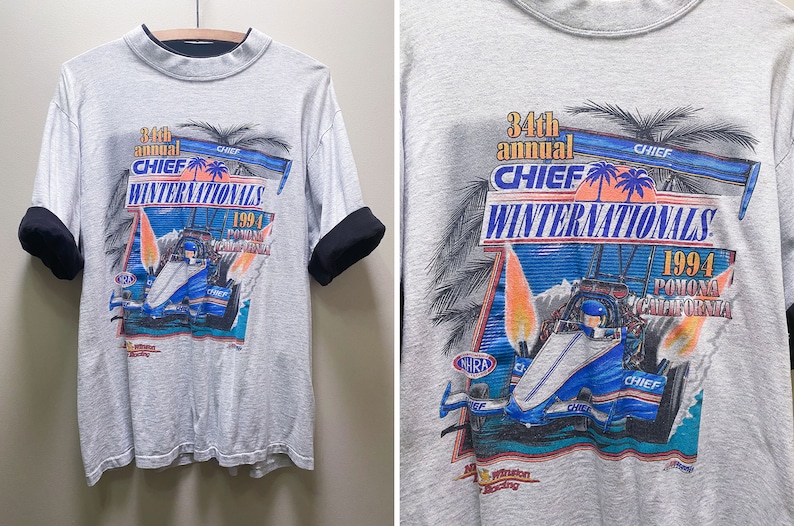 May include: A gray t-shirt with a graphic of a race car and palm trees. The text on the shirt reads "34th annual CHIEF WINTERNATIONALS 1994 POMONA CALIFORNIA".
