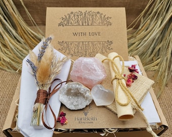May include: A gift box with a kraft paper card that reads "WITH LOVE" and a floral design. The box contains a bundle of dried flowers, crystals, a scroll tied with twine, and dried rose petals. The crystals include a rose quartz.
