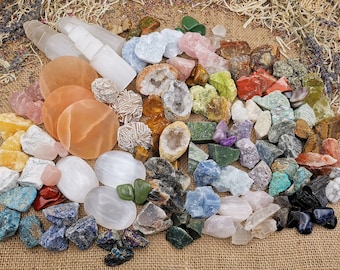May include: A collection of various colorful crystals and stones, including amethyst, rose quartz, selenite, and tiger's eye. The stones are arranged on a burlap background.