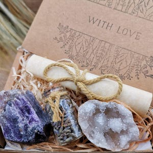 May include: A gift box filled with crystals and a small glass jar of dried lavender. The box is lined with brown paper and has a handwritten note that says "With Love".