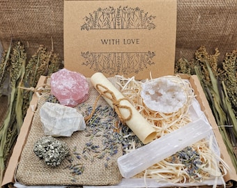 May include: A gift box filled with crystals, including rose quartz, clear quartz, selenite, and pyrite. The box also contains dried lavender and a rolled up scroll with a string tied around it. The box is labeled "With Love."