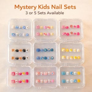 May include: Nine clear plastic cases containing sets of press-on nails with various colorful designs, patterns, and small decorative elements. The text Mystery Kids Nail Sets 3 or 5 Sets Available is displayed at the top of the image.