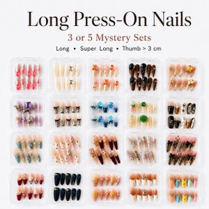 May include: A collection of long press-on nails in various designs, including floral, glitter, and solid colors. The image shows multiple sets of nails in clear plastic containers. Text on the image reads "Long Press-On Nails" and "3 or 5 Mystery Sets."