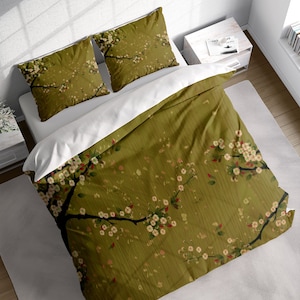 May include: A green duvet cover with a white floral pattern. The duvet cover features a repeating pattern of branches with white flowers and green leaves. The duvet cover is made of a soft, comfortable fabric.