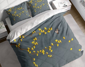 May include: A gray duvet cover with a white branch and yellow leaves printed on it. The duvet cover has two matching pillowcases with the same design.