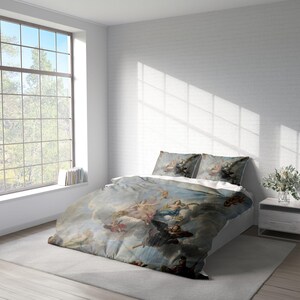 K&ouml;nnte beinhalten: Ein wei&szlig;es Bett mit einem blauen und wei&szlig;en Bettbezug, der ein Gem&auml;lde von Engeln und Wolken zeigt. Der Bettbezug hat einen Vintage-Look und -Feel. Das Bett ist mit wei&szlig;en Laken und zwei passenden Kissenbez&uuml;gen bezogen.