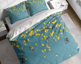 May include: A teal blue duvet cover with a white background features a yellow ginkgo leaf branch with small brown birds and a birdcage. The duvet cover has a quilted pattern.