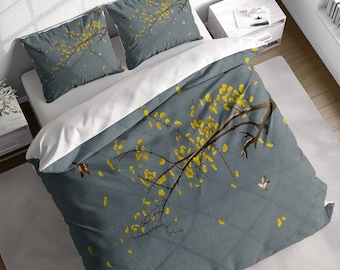 May include: A gray duvet cover with a white floral pattern and small birds. The duvet cover has a branch with yellow flowers and leaves.