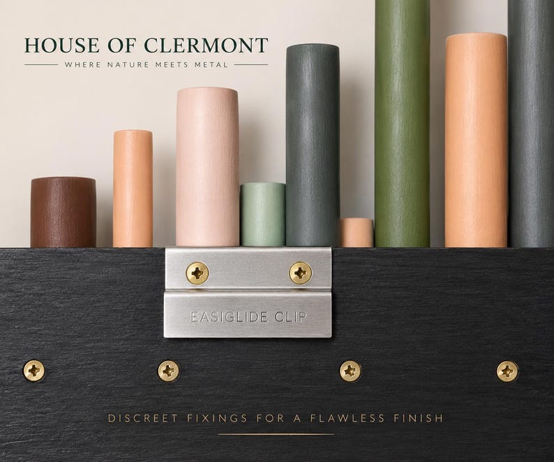 May include: A black wooden panel featuring a silver metal EASIGLIDE CLIP secured with two brass screws. Above the panel, a row of cylindrical pegs in various colors including brown, peach, pink, sage green, dark gray, and olive green are displayed.