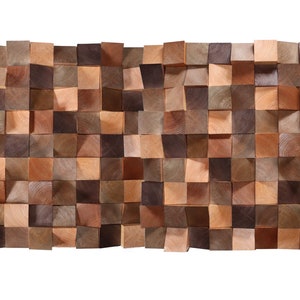 Könnte beinhalten: Eine Wandverkleidung aus Holzblöcken in verschiedenen Brauntönen, die in einem versetzten Muster angeordnet sind. Die Blöcke sind alle gleich groß und gleich geformt und erzeugen einen strukturierten, dreidimensionalen Effekt.