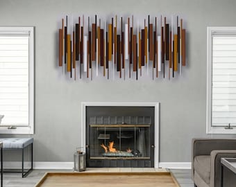 May include: A wall-mounted metal sculpture composed of numerous vertical rods of varying lengths and thicknesses. The rods are arranged in a horizontal pattern and feature a colour palette of dark brown, copper, bronze, and white tones.