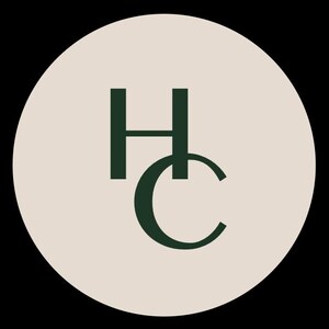 May include: A circular logo featuring a light beige background with the dark green capital letters H and C stacked vertically. The letter H is positioned above the letter C, and both characters are rendered in a clean, sans-serif typeface.