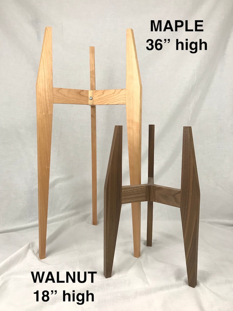 May include: Two plant stands, one made of maple wood and one made of walnut wood. The maple stand is 36 inches tall and the walnut stand is 18 inches tall.