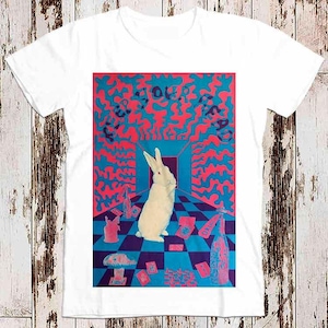 以下が含まれることがあります： 白いTシャツに、チェッカー模様の部屋にいる白いウサギのサイケデリックなグラフィックがプリントされています。テキストは「Feed Your Head」です。