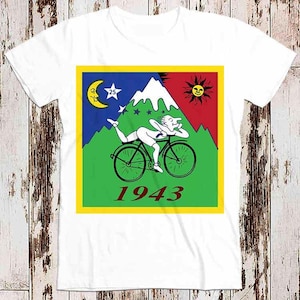 May include: White t-shirt featuring a colourful graphic of a person riding a bicycle with the text "1943" printed on it.