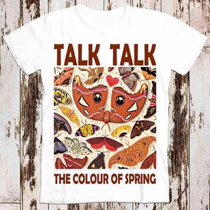 Op de afbeelding: Wit T-shirt met een bruine afbeelding van vlinders en de tekst "TALK TALK THE COLOUR OF SPRING".