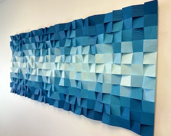 May include: A wall art piece made of wood with a gradient of blue shades, from light blue to dark blue. The wood is arranged in a geometric pattern, creating a textured and modern look.