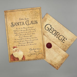 Op de afbeelding: Een brief in vintage-stijl van de Kerstman, met een handgeschreven bericht en een illustratie van de Kerstman. Een envelop geadresseerd aan "GEORGE" met een rode waszegel is ook inbegrepen. De brief staat op verouderd papier.
