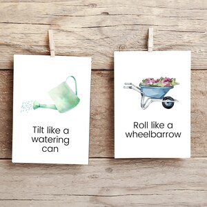 K&ouml;nnte beinhalten: Zwei wei&szlig;e Karten mit Illustrationen und Text. Die linke Karte zeigt eine gr&uuml;ne Gie&szlig;kanne, die Wasser gie&szlig;t. Der Text lautet "Tilt like a watering can". Die rechte Karte zeigt eine blaue Schubkarre mit Blumen. Der Text lautet "Roll like a wheelbarrow".