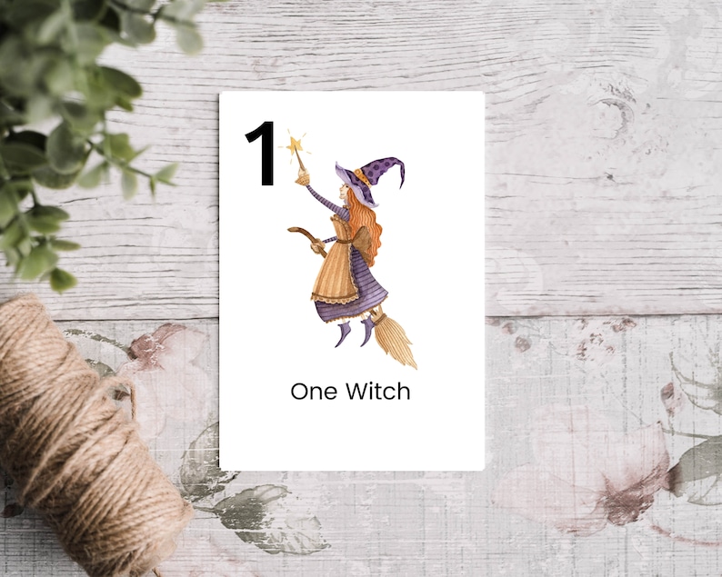 Puede incluir: Una tarjeta flash imprimible con una bruja de dibujos animados volando en una escoba con una estrella en la mano. La tarjeta tiene el n&uacute;mero "1" y el texto "One Witch".
