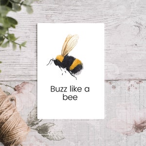 K&ouml;nnte beinhalten: Eine Aquarell-Illustration einer Hummel mit schwarzen und gelben Streifen, die Fl&uuml;gel ausgebreitet. Der Text "Buzz like a bee" steht unter der Biene.