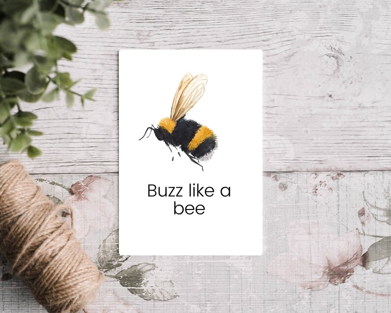 K&ouml;nnte beinhalten: Eine Aquarell-Illustration einer Hummel mit schwarzen und gelben Streifen, die Fl&uuml;gel ausgebreitet. Der Text "Buzz like a bee" steht unter der Biene.