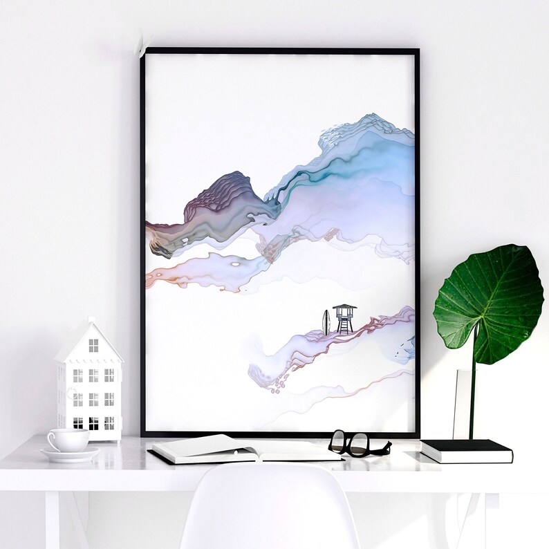 Pu&ograve; includere: Stampa d'arte astratta con sfondo bianco e forme simili ad acquerello blu, viola e marrone. Una piccola silhouette nera di una cabina di salvataggio con una tavola da surf si trova nell'angolo in basso a destra.