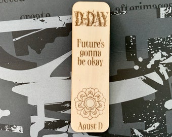 May include: Wooden bookmark with a D-Day theme. It features the text "D-Day" and "Future's gonna be okay" with a floral design and the text "August D".