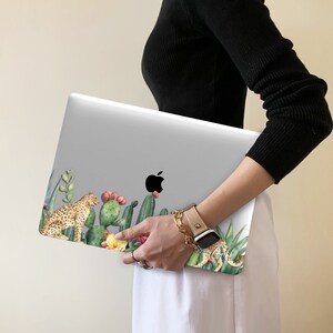 May include: A white laptop with a colorful sticker featuring a leopard, cacti, and flowers. The sticker has the text "Girls" on it.