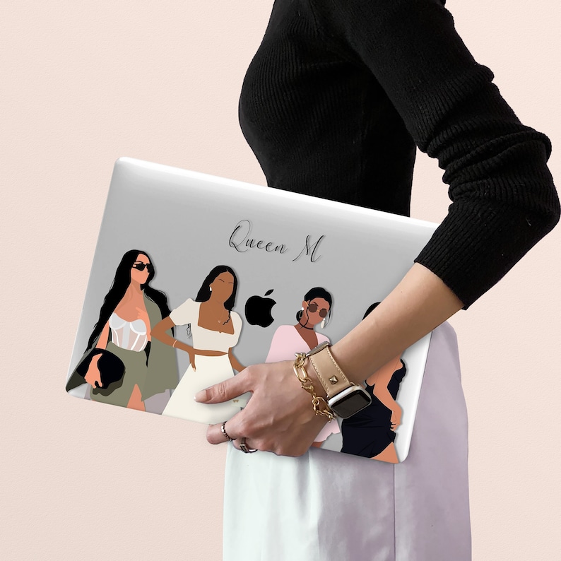 May include: A gray laptop skin with a design of four women in different poses. The text "Queen M" is printed on the skin.