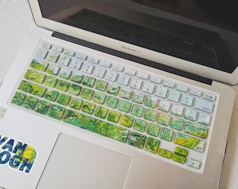 May include: A laptop keyboard cover with a green and yellow artistic design, resembling a painting. The cover is on a MacBook Air laptop. A sticker with the words "VAN GOGH" is on the laptop.