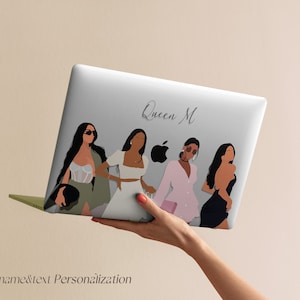 May include: A white laptop with a design featuring four women in different outfits and the text "Queen M".