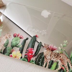 May include: Clear laptop case with a tropical design featuring two leopards, cacti, and flowers. The case is personalized with the name "Chainette" in white lettering.