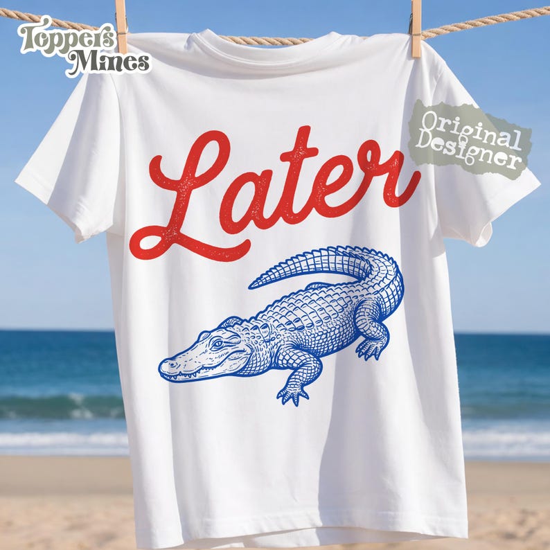May include: White t-shirt with the word "Later" in red script above a blue alligator illustration. The shirt is hanging on a clothesline with a beach background. The words "Toppers Mines" and "Original Designer" are also visible.