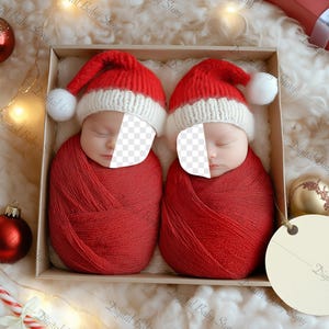May include: Two babies wearing red Santa hats and swaddled in red blankets are sleeping in a wooden box. The box is surrounded by Christmas decorations, including a gingerbread man, ornaments, and a small wooden Christmas tree.