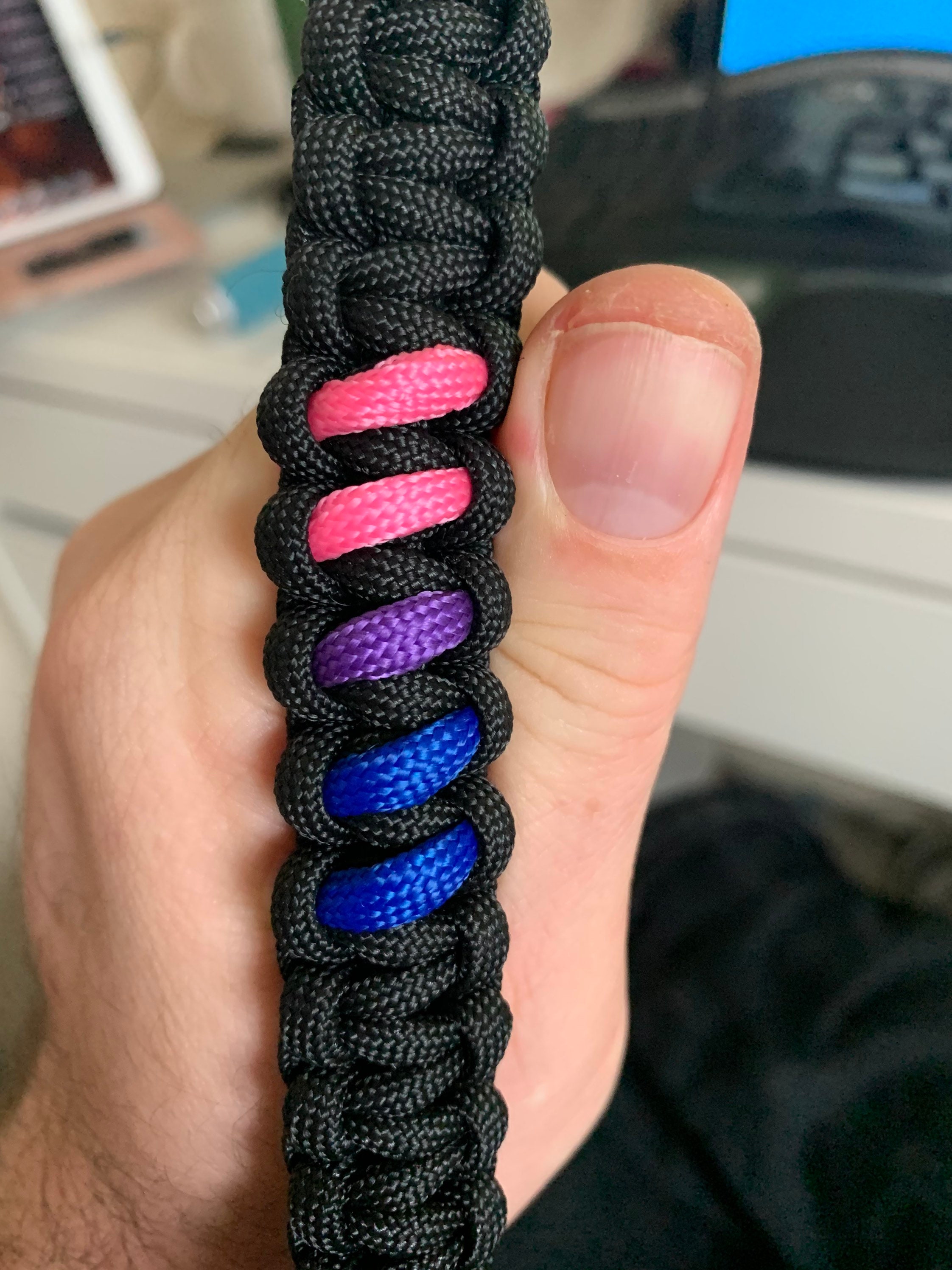 My bisexual pride paracord bracelet. First time making paracord accessories,  I hope to make a collar or other things in the future. A pineapple charm  because my wife and I love pineapples. 