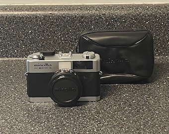 Minolta Hi-Matic F camera with a Minolta 20 flash unit. Comes With Original Case