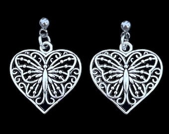 May include: Silver heart-shaped earrings with a delicate butterfly design. The earrings have a filigree pattern and are perfect for adding a touch of elegance to any outfit.