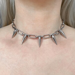 Punk spike choker necklace with stainless steel chain and silver plated cone spike charms worn around neck