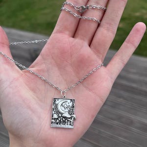 The model places the mushroom pendant against the palm of her hand. This is to be used as a size reference for the charm. For exact measurements, please see the item description.