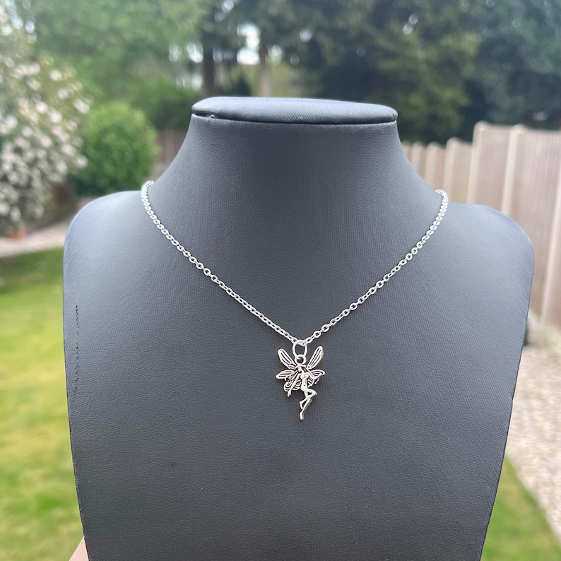 The silver fairy necklace is photographed in this image against a black necklace display model. This is to represent what the necklace looks like once worn in real life.